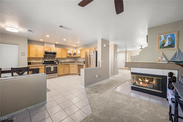 kitchen with light tile patterned flooring, ventilation hood, light brown cabinets, and stainless steel appliances