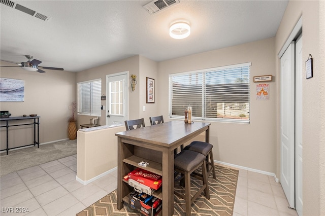 dining area with ceiling fan, a textured ceiling, and light tile patterned floors