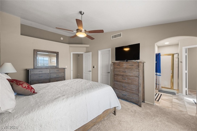 bedroom featuring ceiling fan, connected bathroom, and light carpet