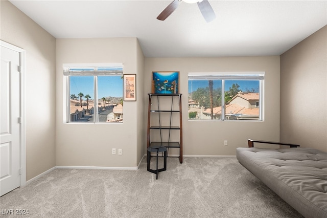 sitting room with ceiling fan and light colored carpet