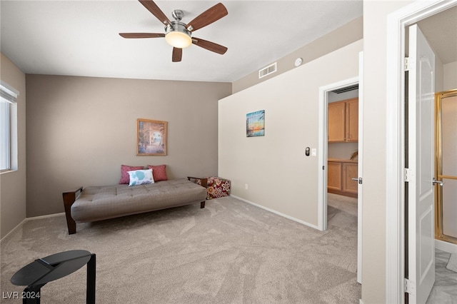 living area with ceiling fan, light colored carpet, and vaulted ceiling