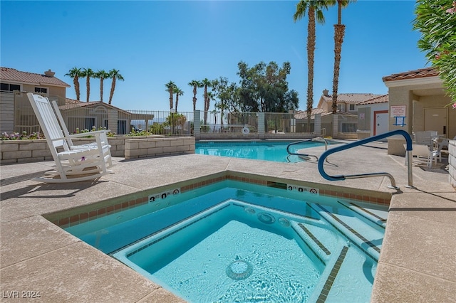 view of pool featuring a hot tub and a patio area