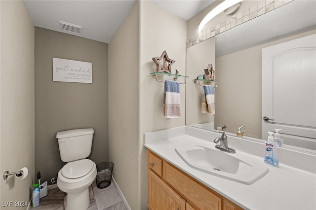 bathroom featuring vanity, toilet, and tile patterned floors