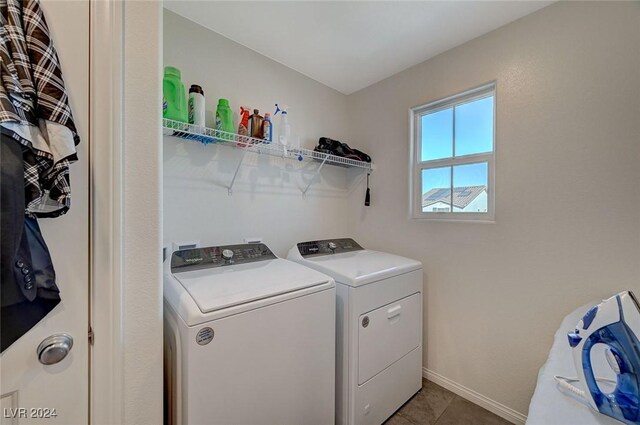 washroom with tile patterned floors, baseboards, washer and dryer, and laundry area