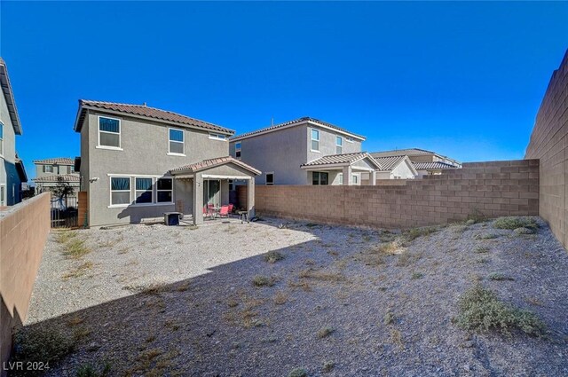 back of house with a fenced backyard and stucco siding