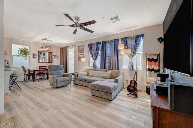 living area with light wood-type flooring, a ceiling fan, and visible vents
