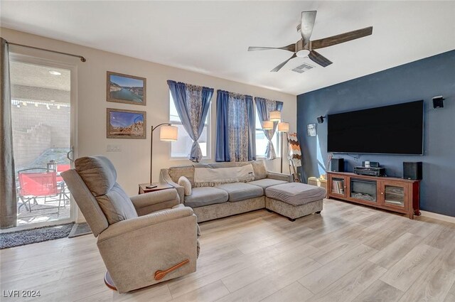 living room featuring light wood-style flooring, ceiling fan, and visible vents