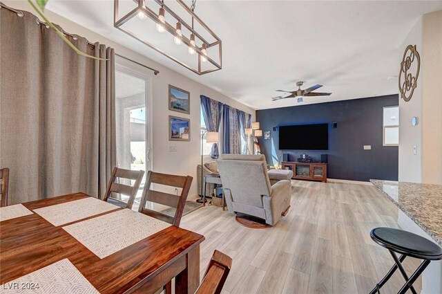 dining area featuring light wood-type flooring, baseboards, and ceiling fan