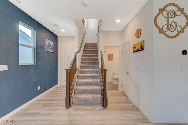 stairway with visible vents, baseboards, recessed lighting, and wood finished floors