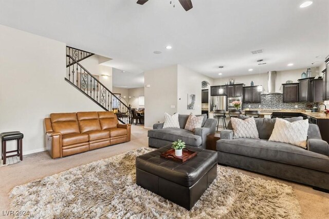 carpeted living room with ceiling fan and sink