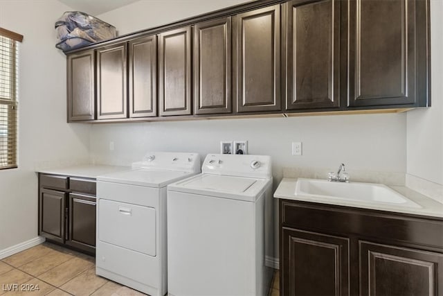 laundry area with light tile patterned floors, separate washer and dryer, cabinets, and sink