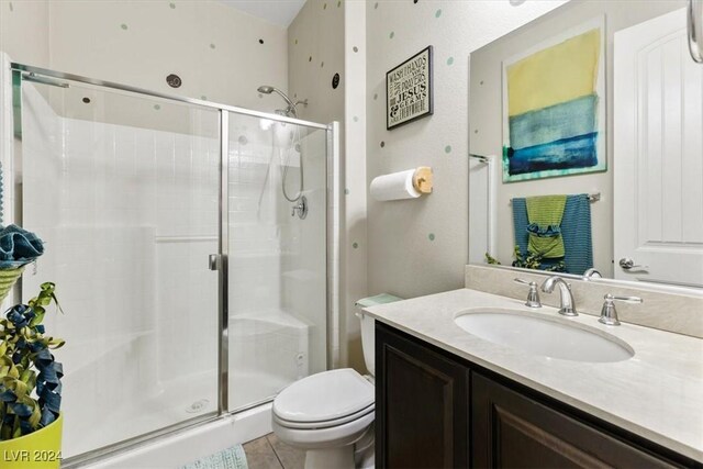 bathroom featuring vanity, tile patterned flooring, toilet, and a shower with shower door