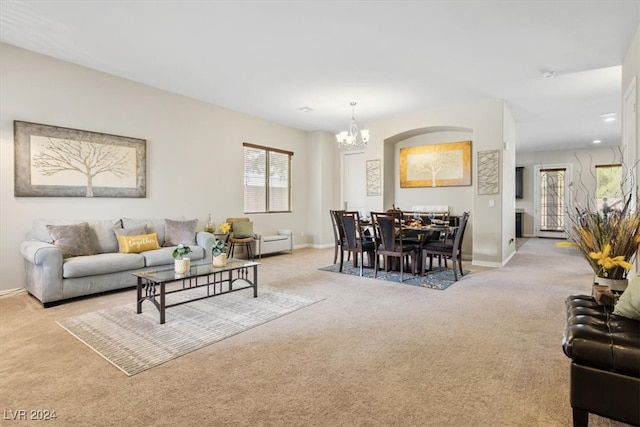 living room featuring light carpet and a notable chandelier