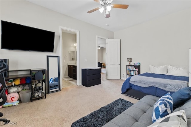 bedroom featuring light carpet, ensuite bath, and ceiling fan