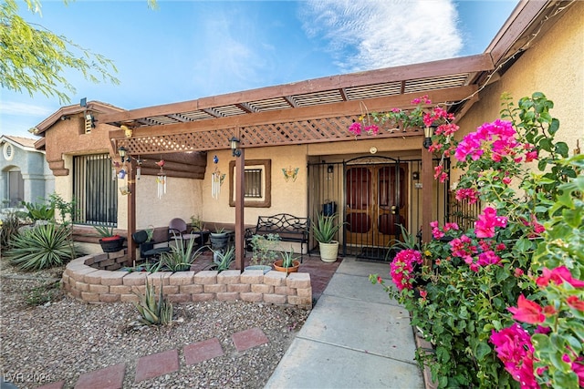 property entrance with a pergola and a patio