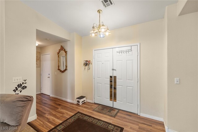 foyer featuring hardwood / wood-style floors and an inviting chandelier