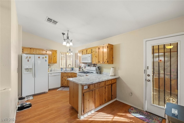 kitchen featuring white appliances, light hardwood / wood-style floors, kitchen peninsula, pendant lighting, and plenty of natural light