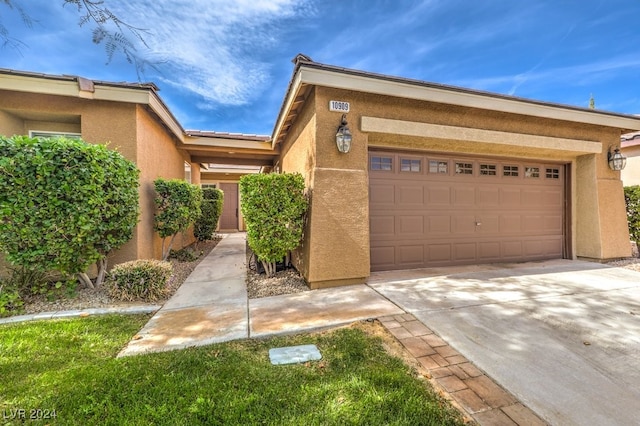 view of front facade featuring a garage, driveway, and stucco siding