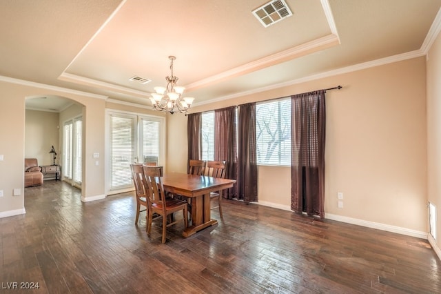 dining room featuring a tray ceiling, arched walkways, visible vents, dark wood-type flooring, and a healthy amount of sunlight