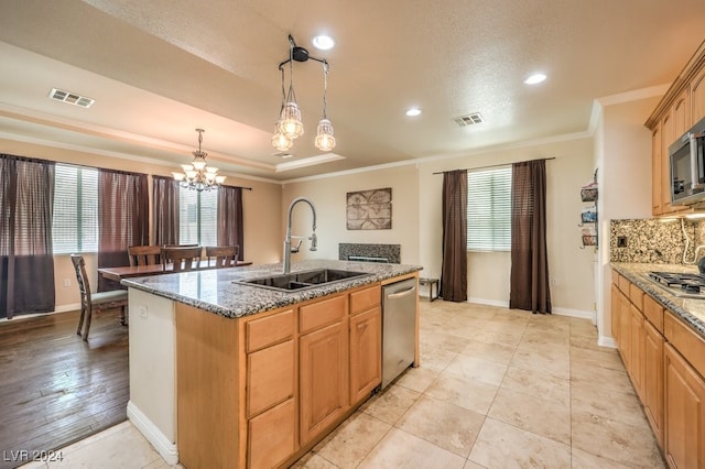 kitchen featuring visible vents, a kitchen island with sink, stainless steel appliances, crown molding, and a sink