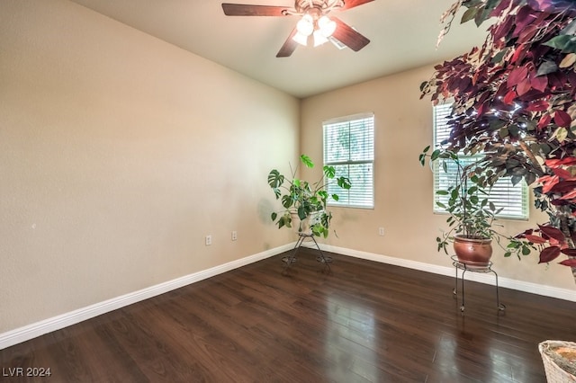 spare room with dark wood-style floors, ceiling fan, and baseboards