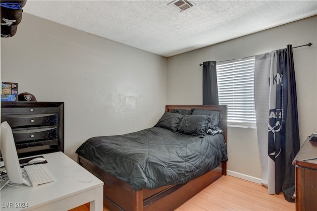 bedroom featuring a textured ceiling and light wood-type flooring