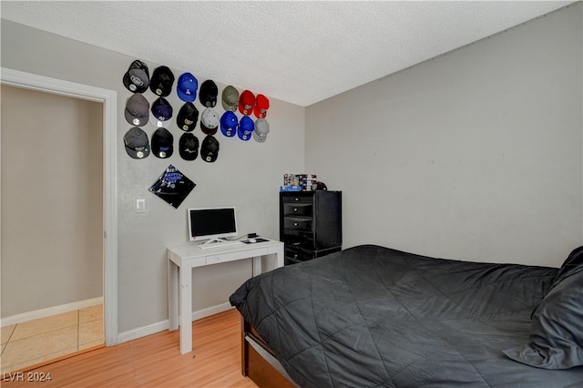 bedroom featuring a textured ceiling and light wood-type flooring