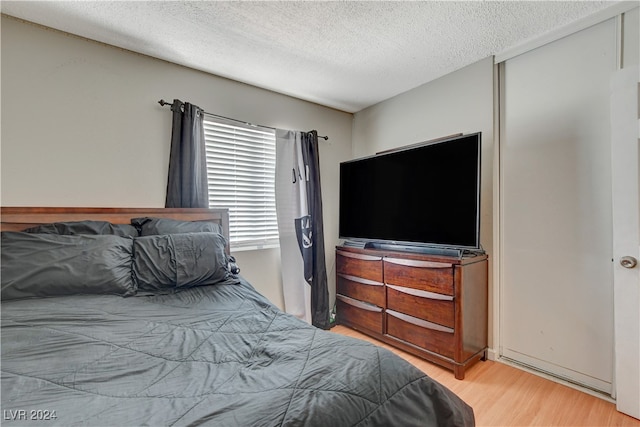 bedroom with wood-type flooring and a textured ceiling