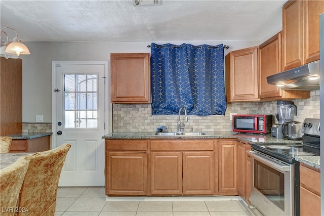 kitchen featuring light tile patterned flooring, light stone countertops, stainless steel range with electric stovetop, and sink