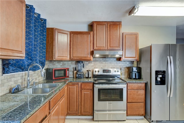 kitchen featuring appliances with stainless steel finishes, sink, light tile patterned floors, and backsplash