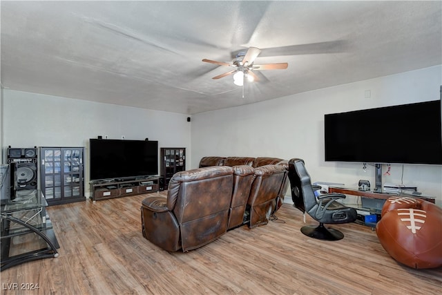 living room with ceiling fan, a textured ceiling, and light hardwood / wood-style flooring