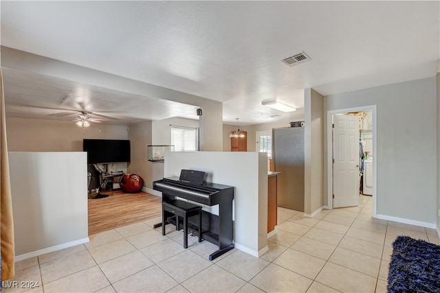 interior space with ceiling fan with notable chandelier and light hardwood / wood-style floors