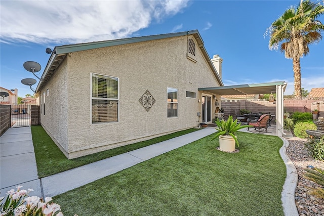 back of property featuring a patio and a lawn