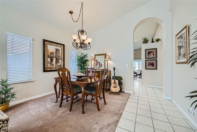 carpeted dining room with lofted ceiling and a chandelier