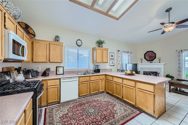 kitchen featuring light tile patterned flooring, kitchen peninsula, white appliances, and plenty of natural light