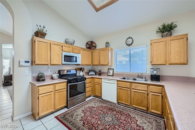 kitchen featuring lofted ceiling, sink, light tile patterned floors, and white appliances