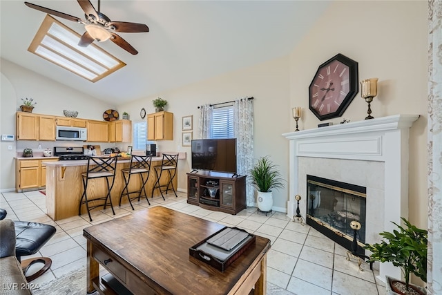 living room featuring ceiling fan, light tile patterned flooring, a fireplace, and vaulted ceiling