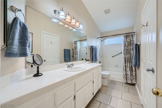 full bathroom featuring shower / bath combination with curtain, toilet, tile patterned floors, vaulted ceiling, and vanity