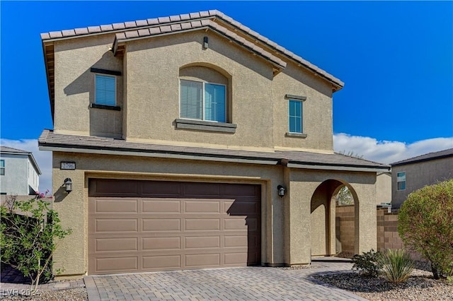 view of front of house featuring a garage, decorative driveway, and stucco siding