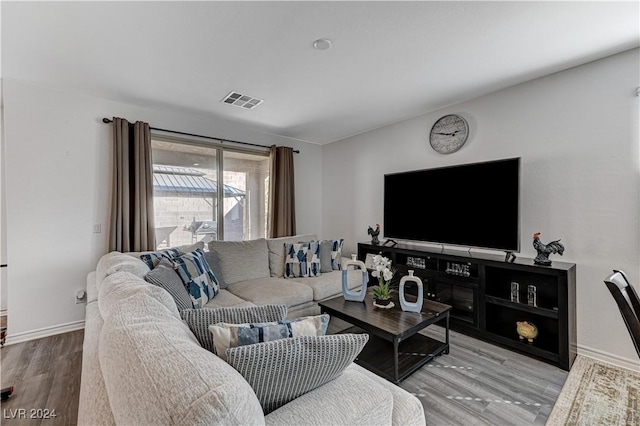 living area featuring visible vents, baseboards, and wood finished floors