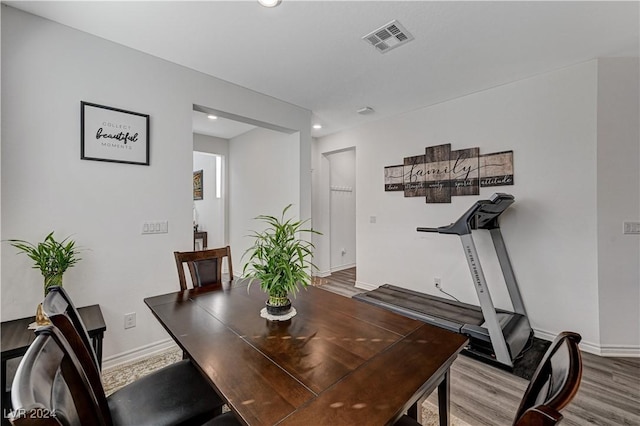 dining room featuring wood finished floors, visible vents, and baseboards