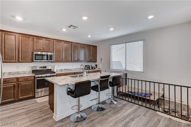 kitchen with light wood finished floors, visible vents, appliances with stainless steel finishes, and a sink