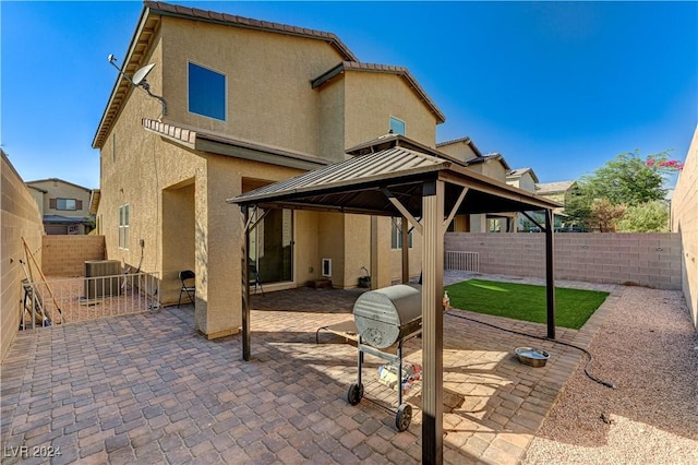 back of house with a gazebo, a patio area, a fenced backyard, and stucco siding