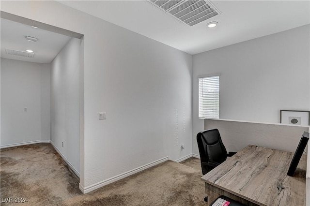 unfurnished office with baseboards, visible vents, and carpet flooring