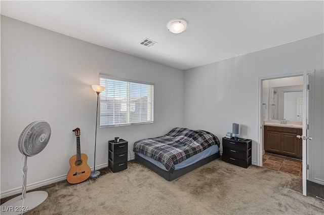 carpeted bedroom featuring connected bathroom, visible vents, a sink, and baseboards