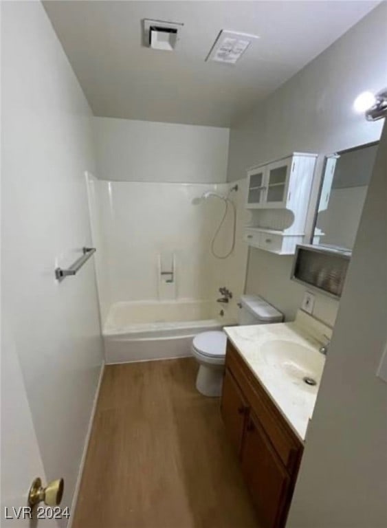 full bathroom with vanity, hardwood / wood-style floors, toilet, and shower / washtub combination