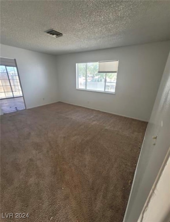 carpeted spare room featuring a textured ceiling