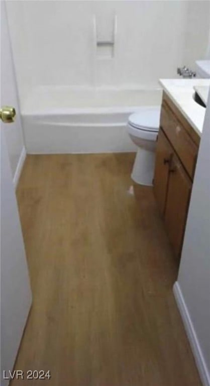 bathroom with wood-type flooring, vanity, and toilet