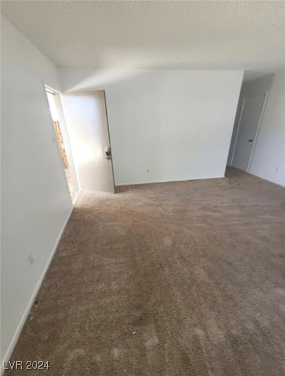 unfurnished room featuring dark carpet