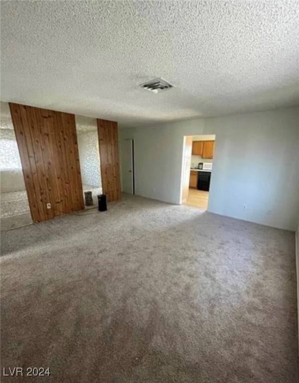 unfurnished living room with carpet floors and a textured ceiling